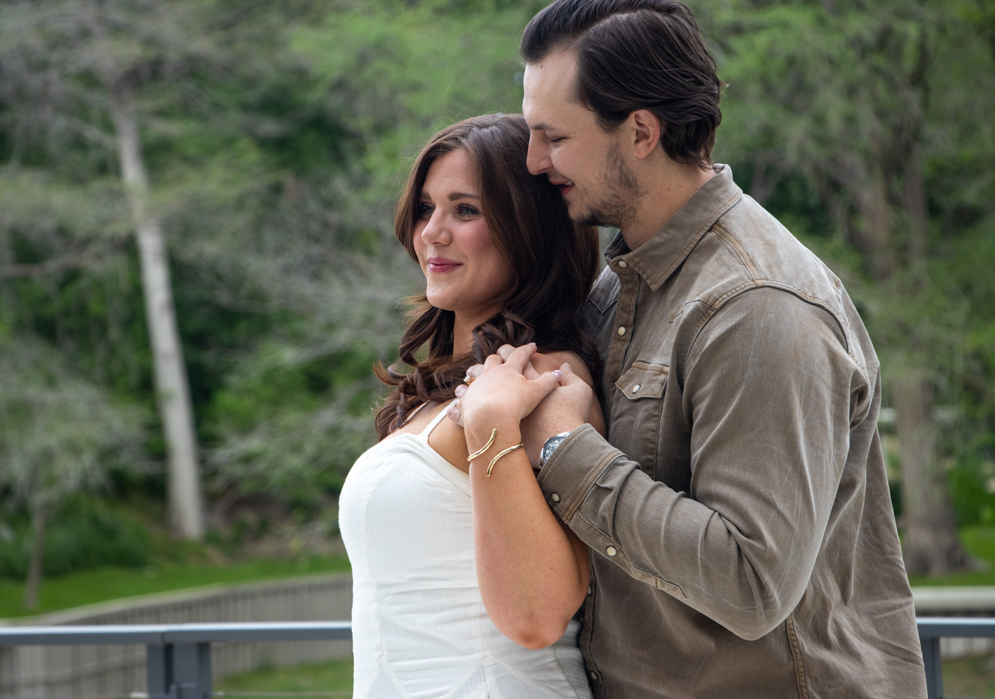 Engaged couple sharing a candid moment by the water